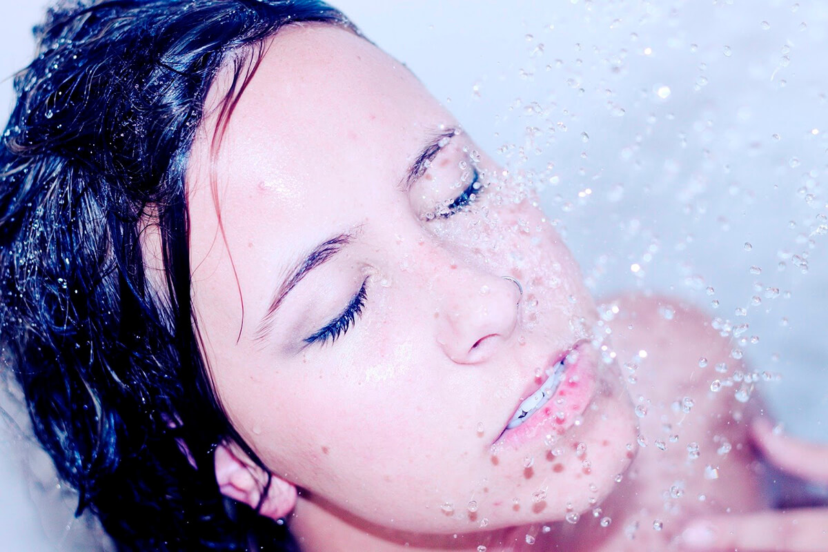 Изображение девушки под струей воды